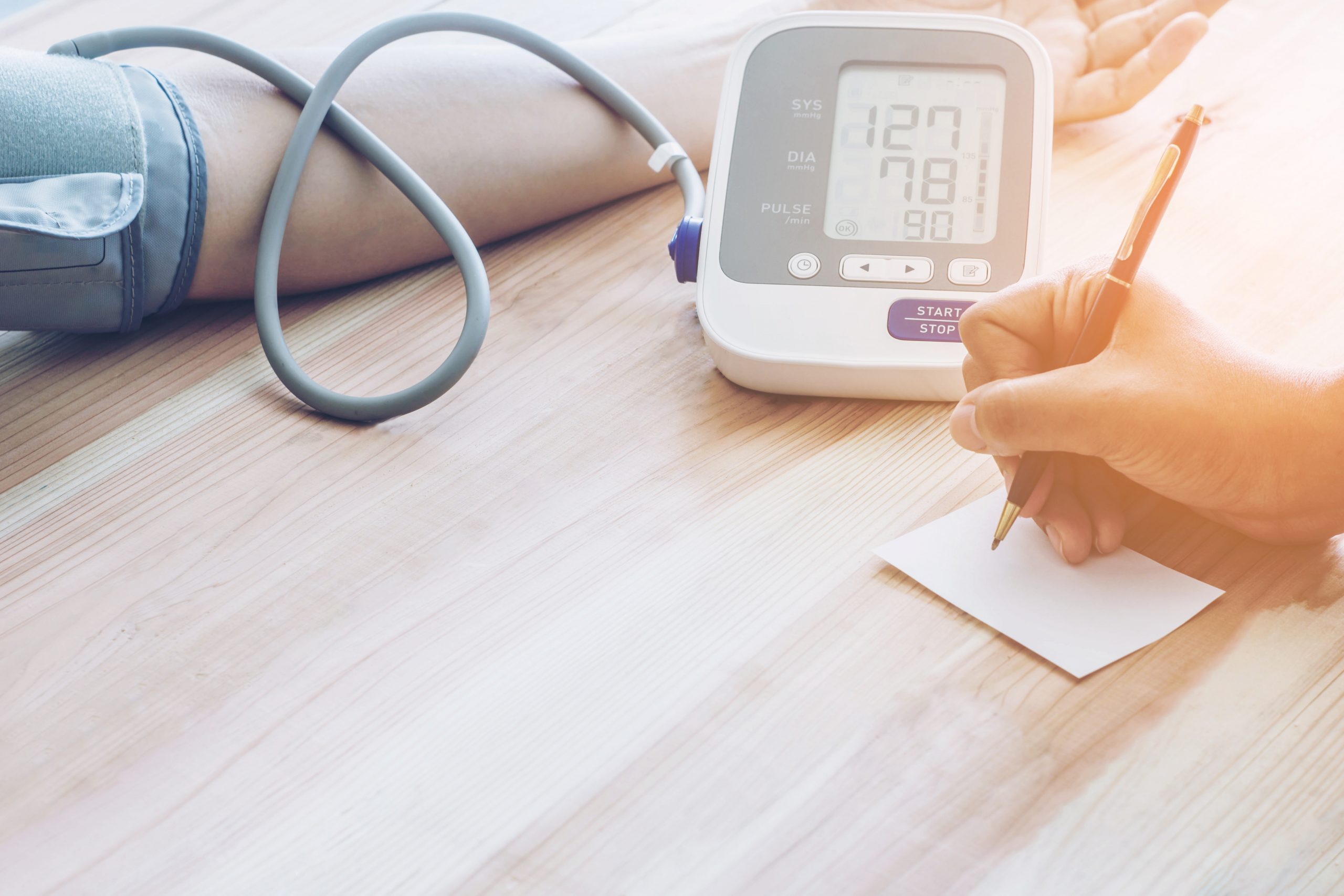 Lekarz mierzy ciśnienie krwi pacjentowy i wynik zapisuje na kartce